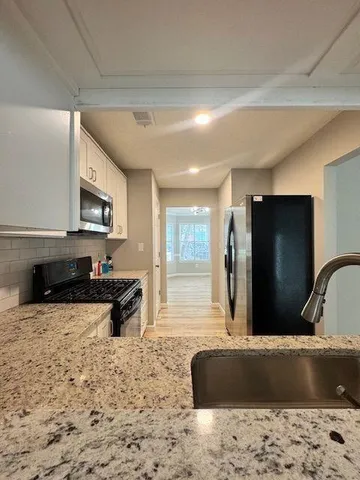a living room with kitchen island furniture and a flat screen tv