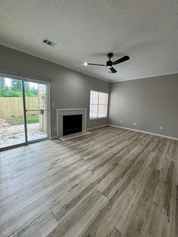 an empty room with ceiling fan and windows