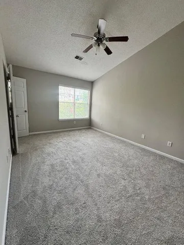 an empty room with a window and a ceiling fan