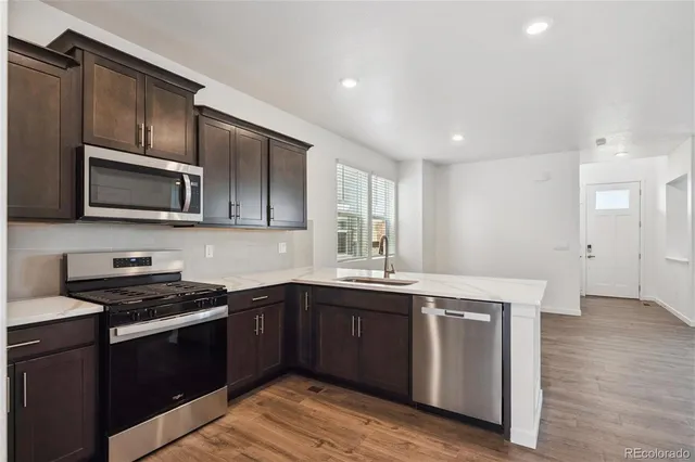 a kitchen with a sink stove top oven and cabinets