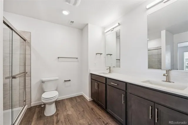 a bathroom with a toilet sink a mirror and shower