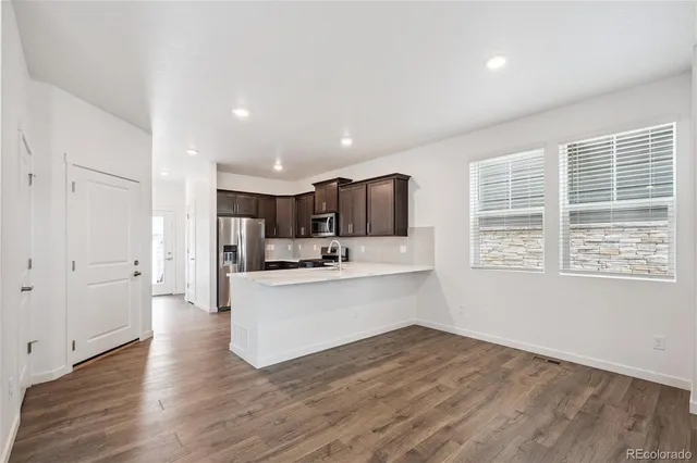 a large white kitchen with wooden floors and white walls