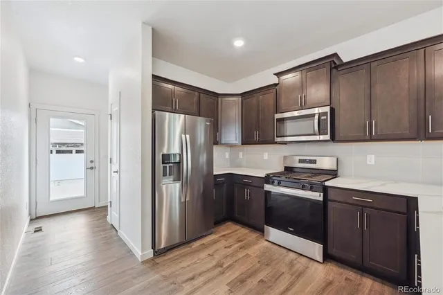 a kitchen with stainless steel appliances granite countertop a refrigerator stove and sink