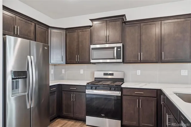 a kitchen with stainless steel appliances granite countertop a refrigerator stove and microwave