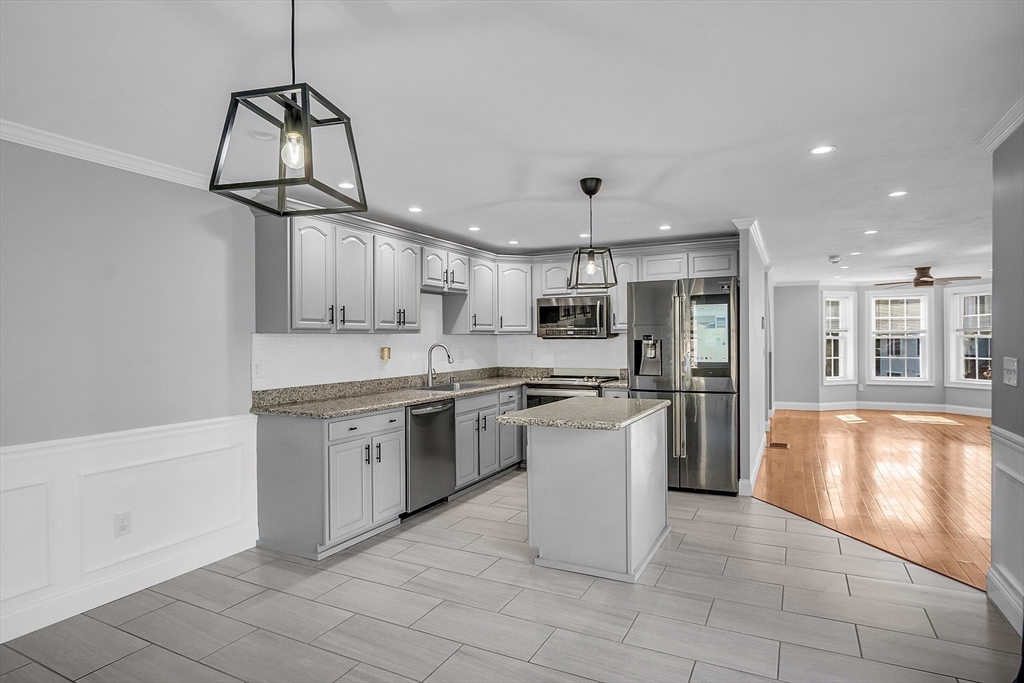 56 Honeysuckle Road Worcester, MA 01607 - Photo 9 of 27 a kitchen with stainless steel appliances granite countertop a sink a stove a refrigerator and island