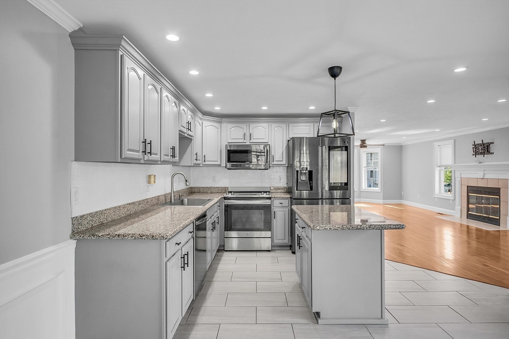 56 Honeysuckle Road Worcester, MA 01607 - Photo 10 of 27 a kitchen with stainless steel appliances granite countertop a refrigerator oven a sink dishwasher and white cabinets with wooden floor