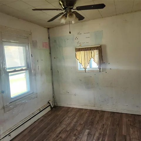 an empty room with a window and a ceiling fan