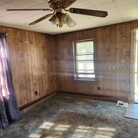 a view of a room with a window and a ceiling fan
