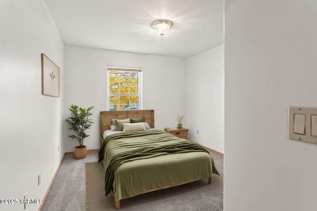 a bedroom with a bed and a potted plant