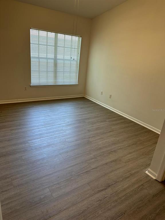4352 South Kirkman Road, Unit 1204 Orlando, FL 32811 - Photo 21 of 22 an empty room with wooden floor and windows