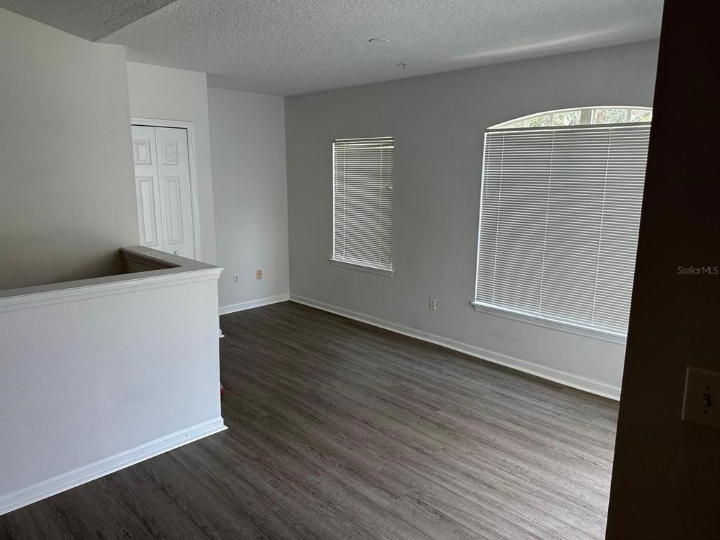 4352 South Kirkman Road, Unit 1204 Orlando, FL 32811 - Photo 7 of 22 an empty room with wooden floor and windows