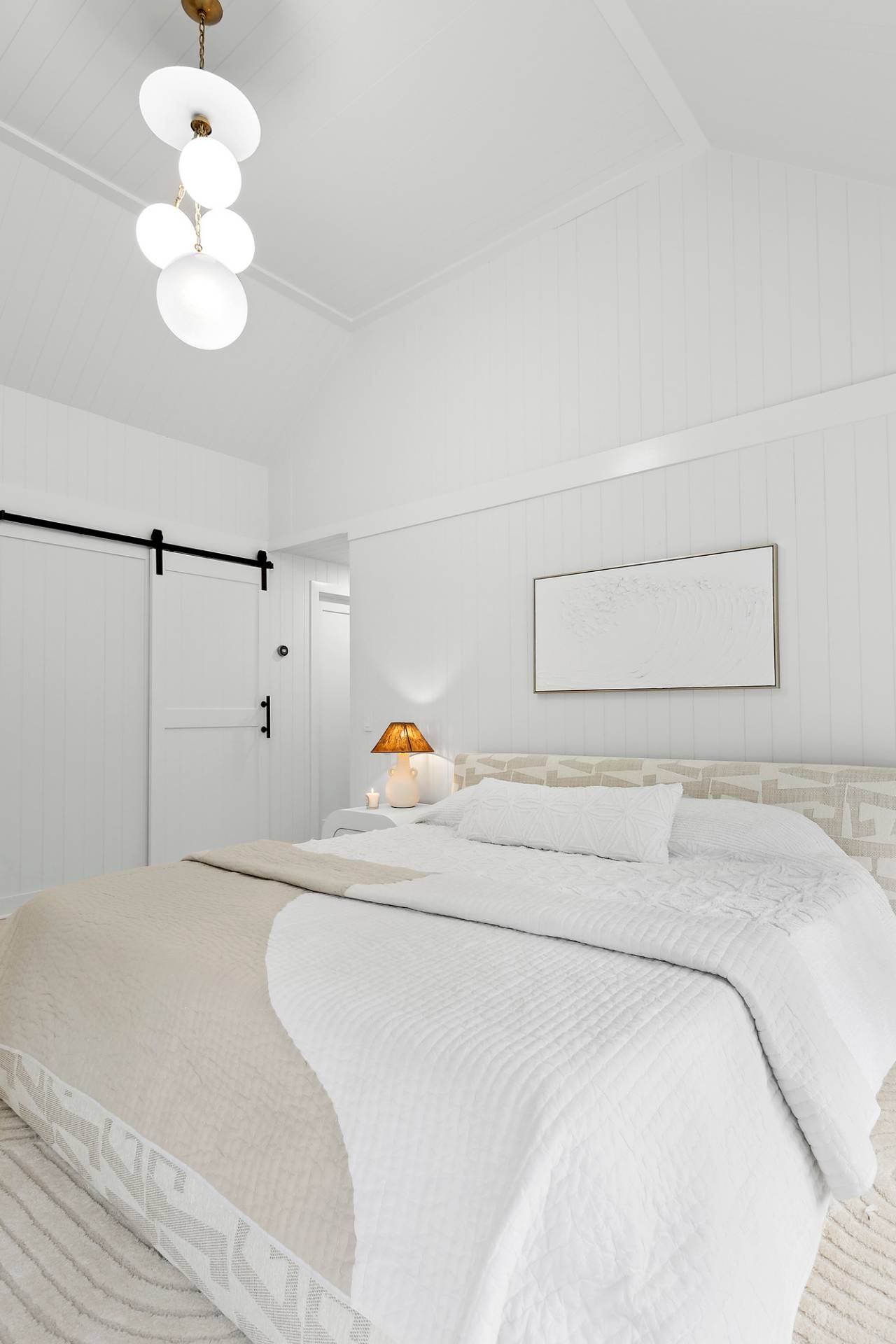 5 Phoebe Scoys Road East Hampton, NY 11937 - Photo 34 of 43 a bedroom with a bed and a chandelier