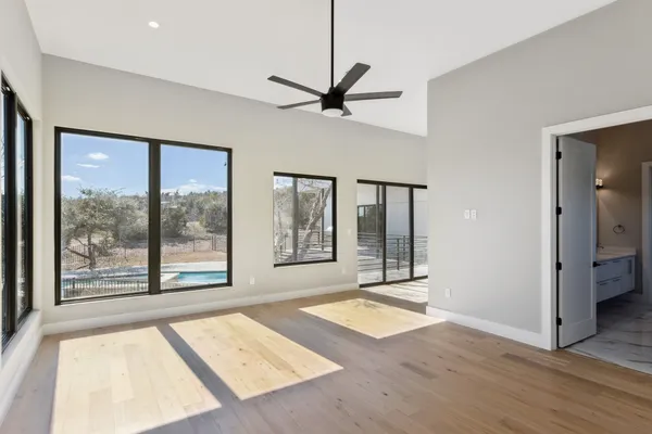 a view of an empty room with window and wooden floor