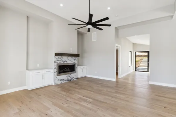 a view of a livingroom with a fireplace and a ceiling fan