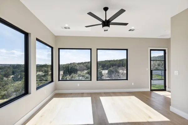 an empty room with wooden floor and windows