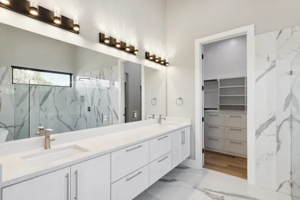 a bathroom with a double vanity sink a mirror and a shower