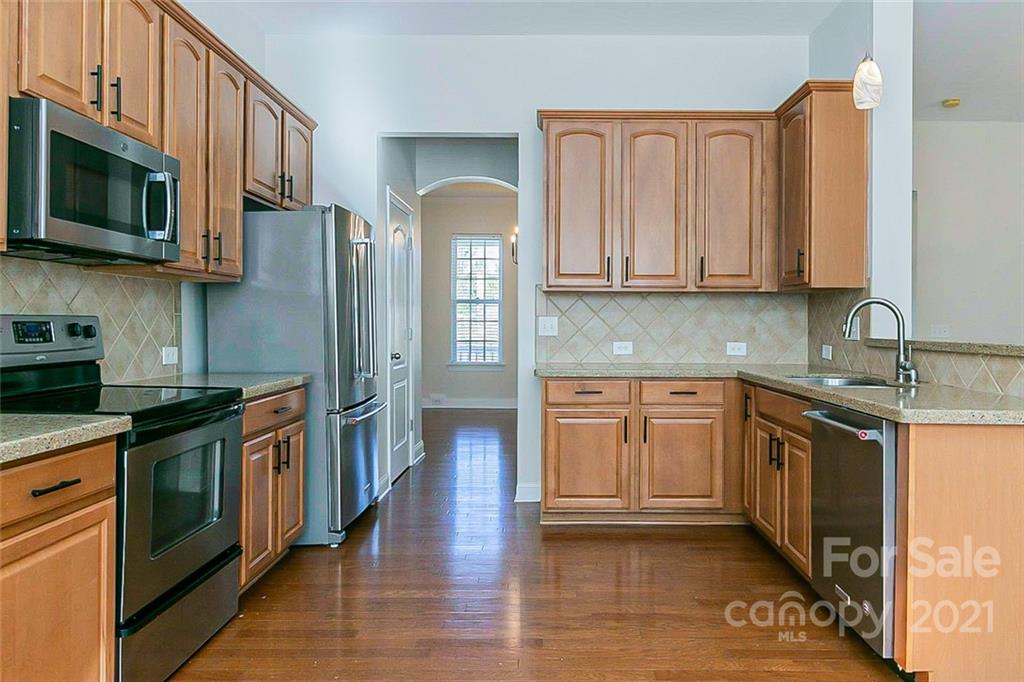 10426 Tom Short Road Charlotte, NC 28277 - Photo 5 of 17 a kitchen with stainless steel appliances granite countertop a refrigerator a stove top oven a sink and dishwasher with wooden floor
