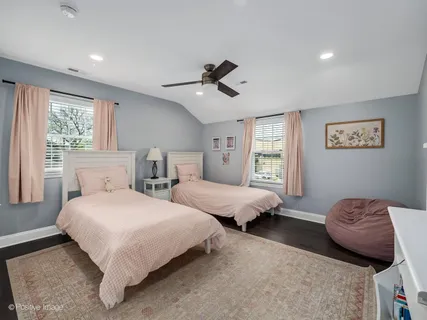 a bedroom with two beds and windows