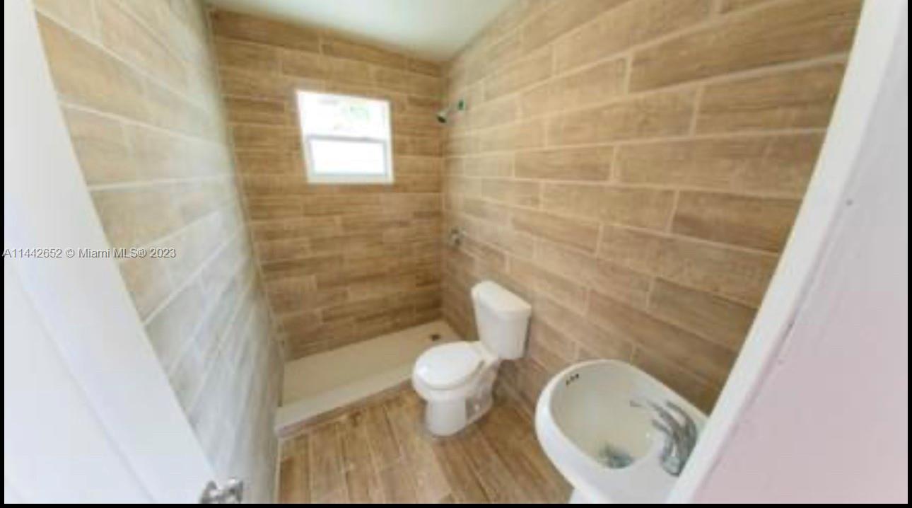 2940 Northwest 88th Street, Unit A Miami, FL 33147 - Photo 2 of 5 a bathroom with a toilet and a shower