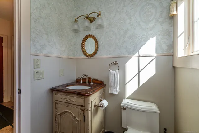 a bathroom with a granite countertop sink a toilet and a window