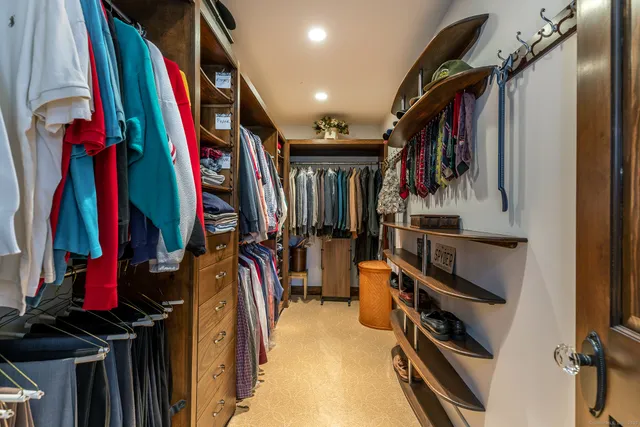 a view of walk in closet with clothes and shoes