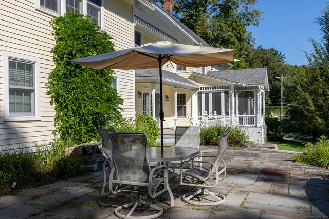 a view of a patio with table and chairs under an umbrella