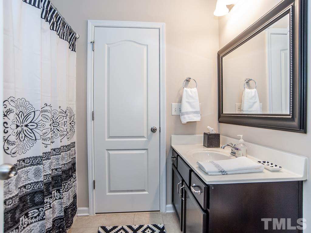 1311 Still Monument Way Raleigh, NC 27603 - Photo 23 of 33 a bathroom with a sink and a mirror