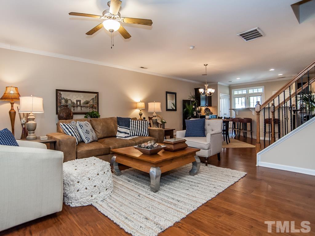 1311 Still Monument Way Raleigh, NC 27603 - Photo 3 of 33 a living room with furniture a rug and a chandelier