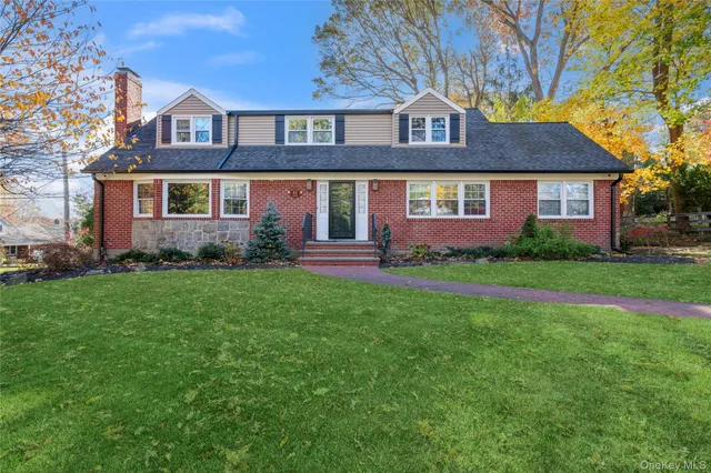 a front view of a house with a yard and trees