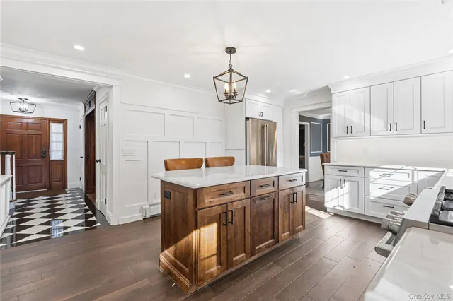 a kitchen that has a lot of cabinets in it and wooden floors