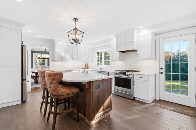 a kitchen with stainless steel appliances granite countertop a stove a sink and a refrigerator