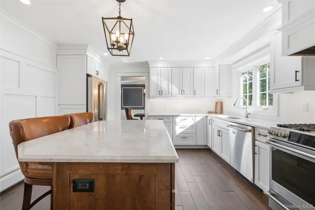 a kitchen with stainless steel appliances granite countertop a kitchen island a stove a table and chairs in it