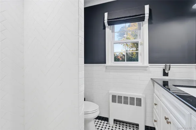 a bathroom with a granite countertop sink toilet and mirror