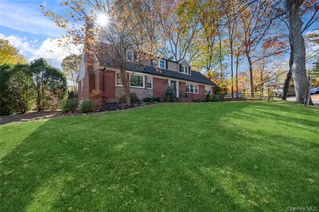 a brick house with a big yard plants and trees