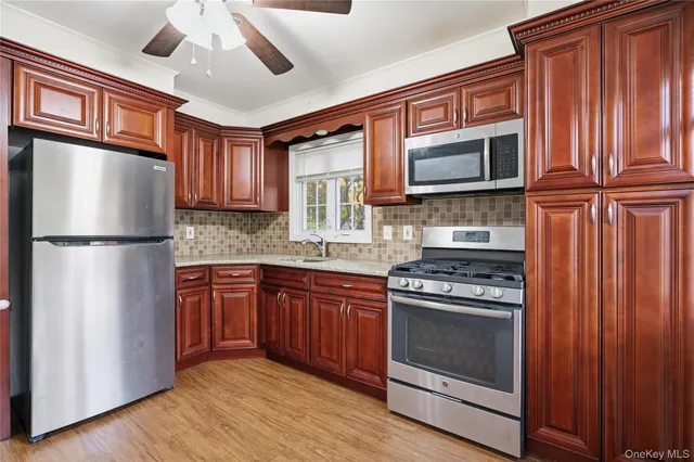 a kitchen with stainless steel appliances granite countertop a refrigerator stove top oven and sink
