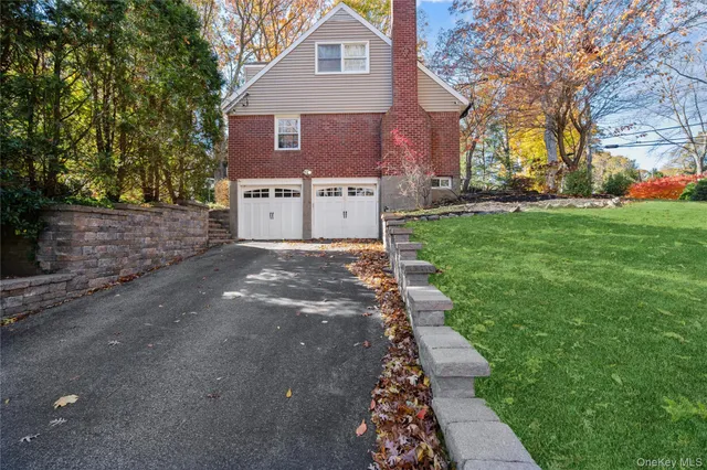 a view of a house with a small yard and a large tree