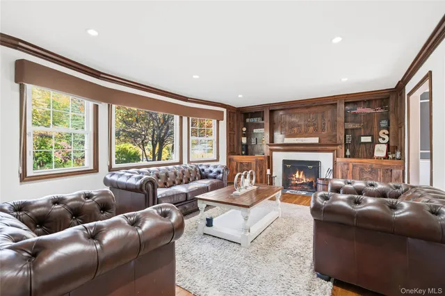 a living room with furniture a large window and a fireplace