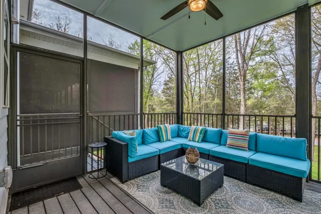 a roof deck with couches and potted plants with wooden floor