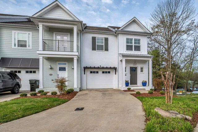 a front view of a house with a yard and trees