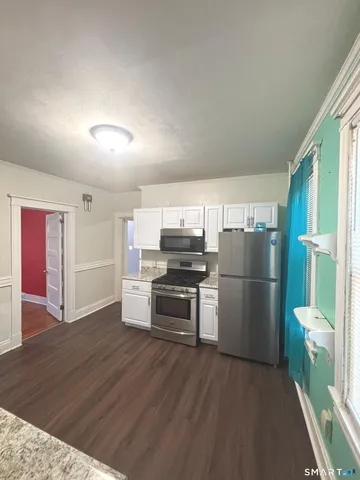 a kitchen with a refrigerator and a stove top oven
