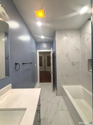 a bathroom with a granite countertop sink a toilet and shower