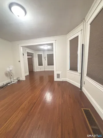 wooden floor in an empty room with a window