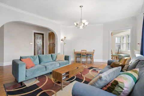 a living room with furniture a fireplace and a chandelier