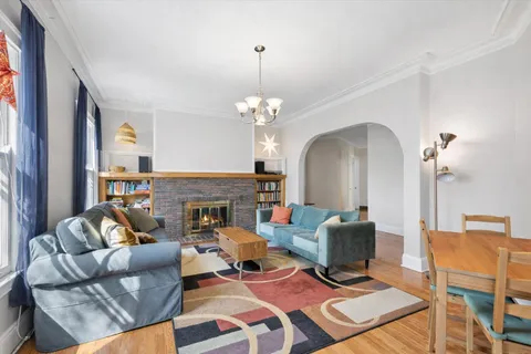 a living room with furniture a fireplace and a chandelier