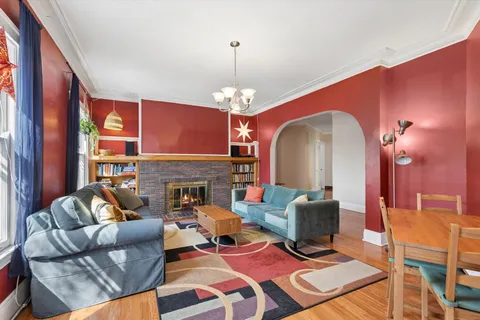 a living room with furniture a fireplace and a chandelier