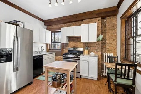 a kitchen with a table chairs refrigerator and cabinets