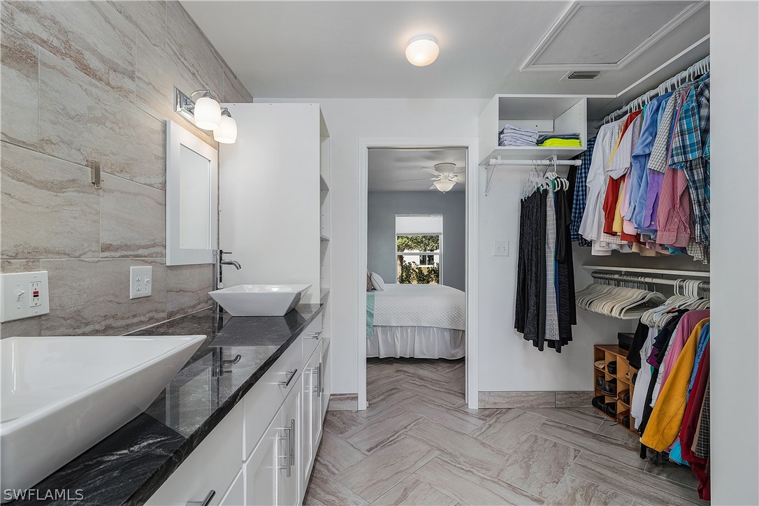 2204 Nelson Road North Cape Coral, FL 33993 - Photo 12 of 22 a spacious bathroom with a double vanity sink a large mirror and shower