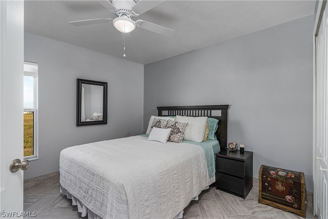 2204 Nelson Road North Cape Coral, FL 33993 - Photo 14 of 22 a bedroom with a bed and a chandelier