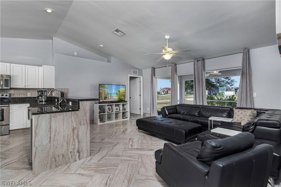 2204 Nelson Road North Cape Coral, FL 33993 - Photo 3 of 22 a living room with furniture and a chandelier