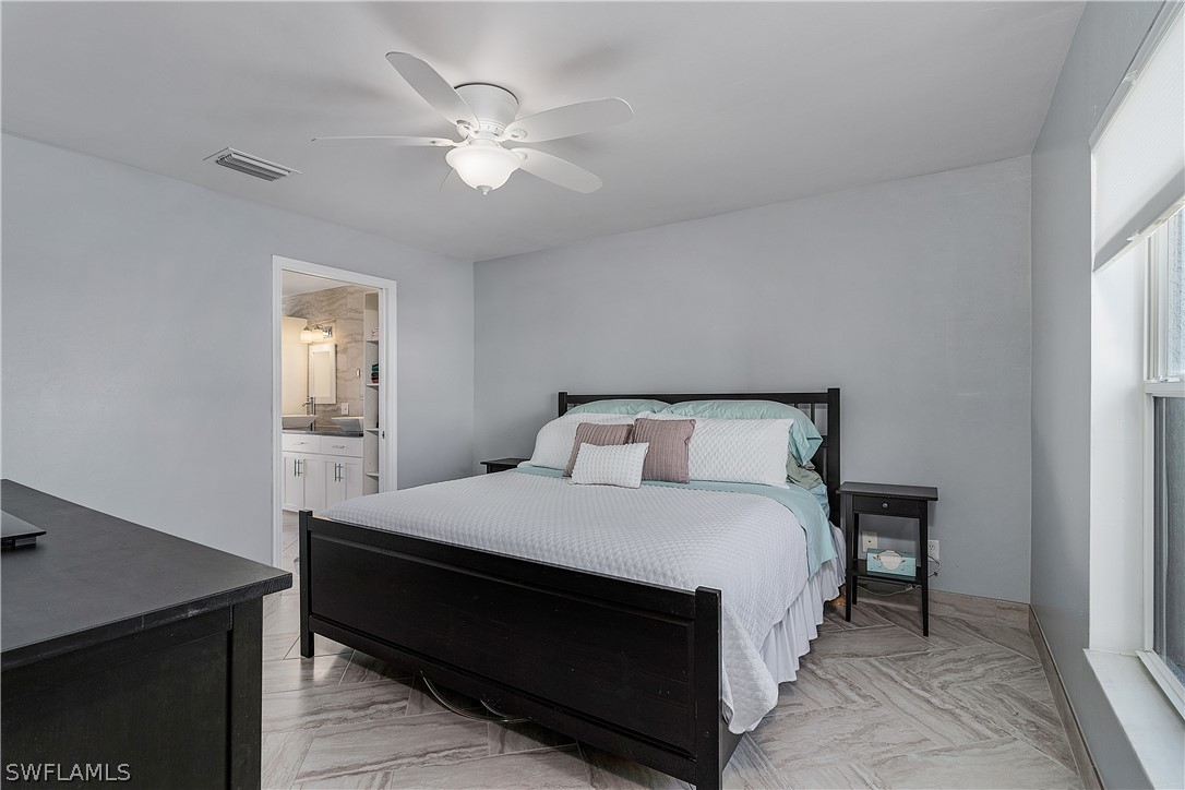 2204 Nelson Road North Cape Coral, FL 33993 - Photo 9 of 22 a bedroom with a bed and a chandelier